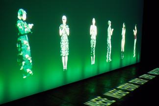 Photo: projection of a pixelated people on a brigh...