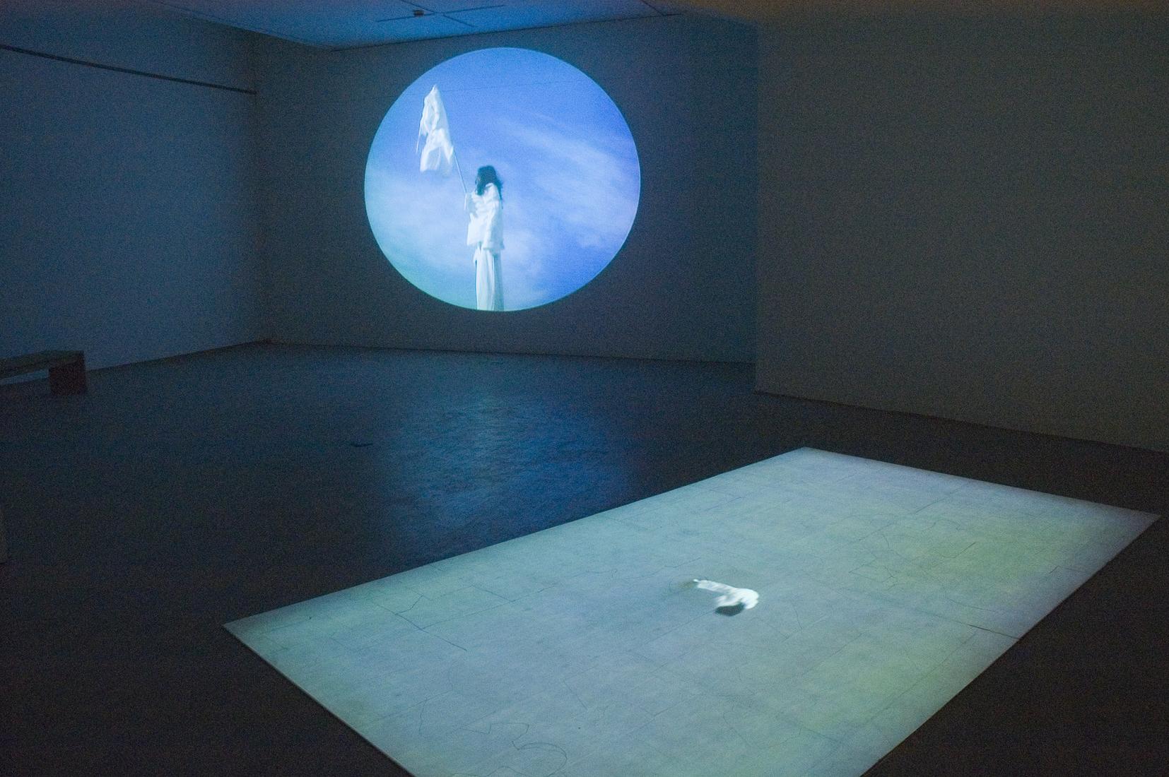 Installtion photo of a dark gallery bathed in blue...
