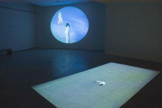 Installtion photo of a dark gallery bathed in blue...
