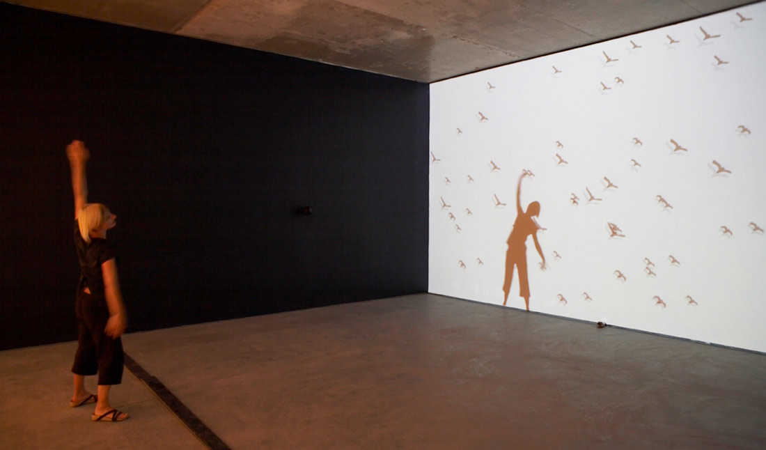 Photo: a person stands in front of a wall projecti...