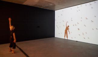 Photo: a person stands in front of a wall projecti...