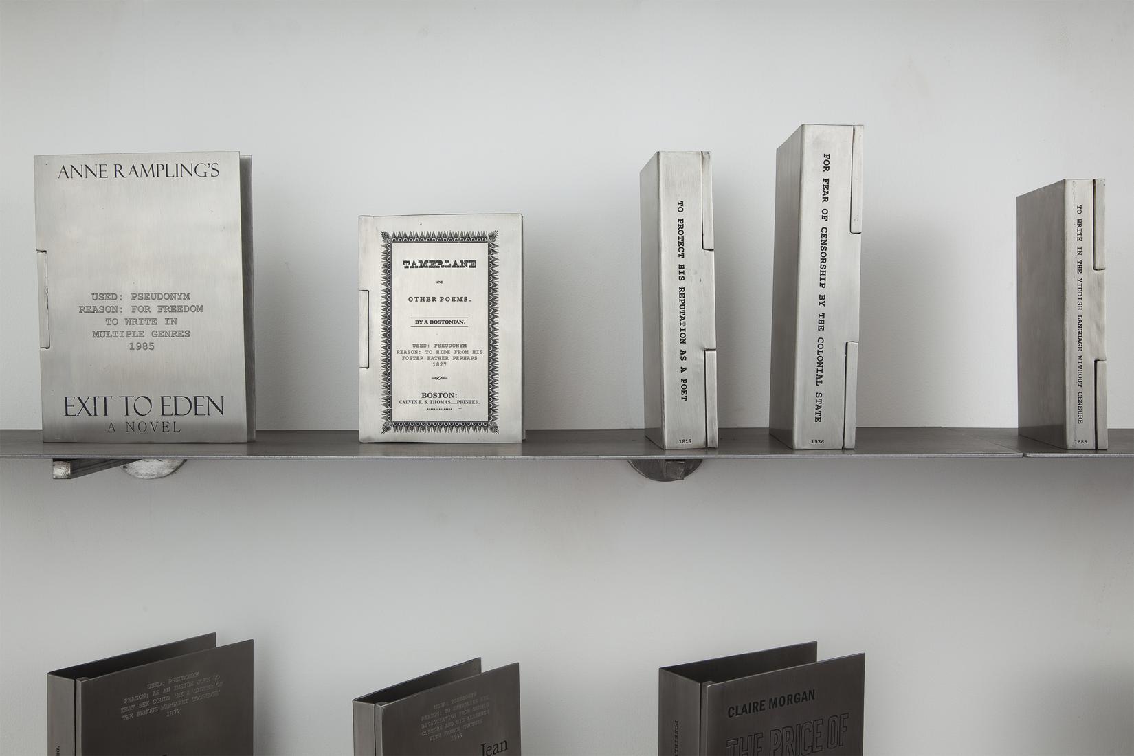 Engraved silver book covers on a metal shelf: Exit...