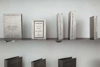 Engraved silver book covers on a metal shelf: Exit...